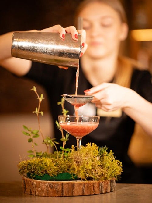 Barmaid pouring a cocktail